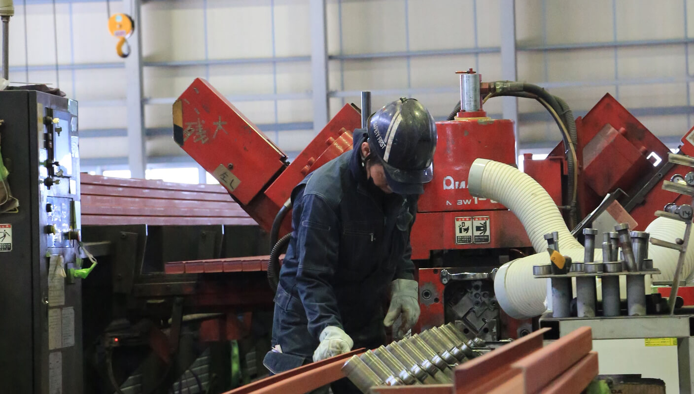 施工図・工作図をもとに、鋼材を指定寸法に切断し、ボルト接合用の孔あけ加工を行う工程です。専用の機械を使用し、寸法精度・直角度・孔位置を厳密に管理します。後工程の精度を左右する、鉄骨製作の基礎となる重要な工程です。