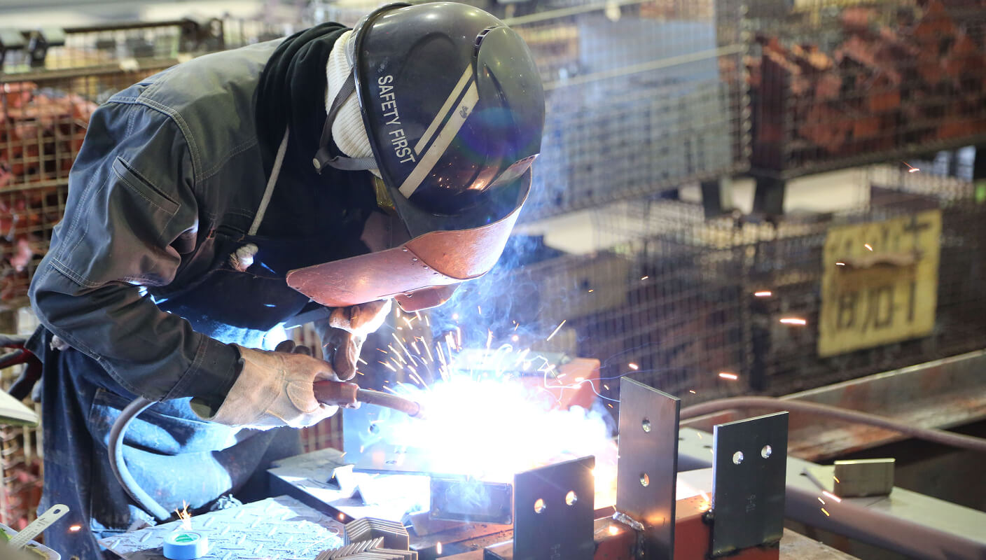 組み立てた部材を、半自動溶接などの方法で本溶接し、構造体として一体化させる工程です。溶接条件や姿勢、ビード形状を管理しながら、強度・品質基準を満たす溶接を行います。鉄骨製作における中核となる、専門性の高い工程です。